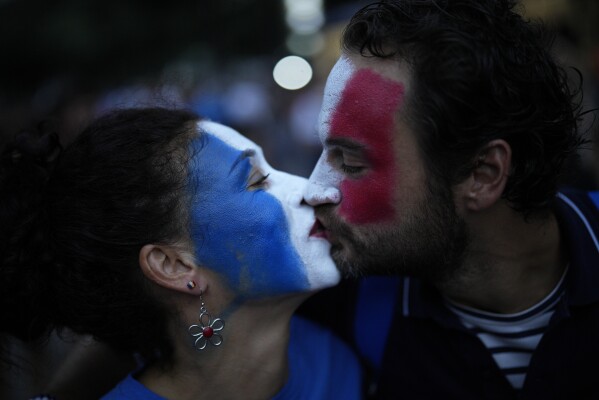 French rugby supporters kiss as they arrive for the Rugby World Cup Pool A match between France and Namibia at the Stade de Marseille in Marseille, France, Thursday, Sept. 21, 2023. (AP Photo/Daniel Cole)
