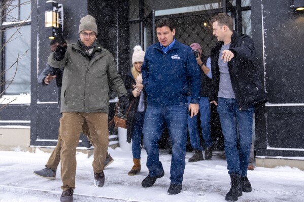 Republican presidential candidate Florida Gov. Ron DeSantis, center, accompanied by his press secretary Bryan Griffin, right, departs after speaking at a Northside Conservatives Club Meeting at The District in Ankeny, Iowa, Friday, Jan. 12, 2024. (AP Photo/Andrew Harnik)