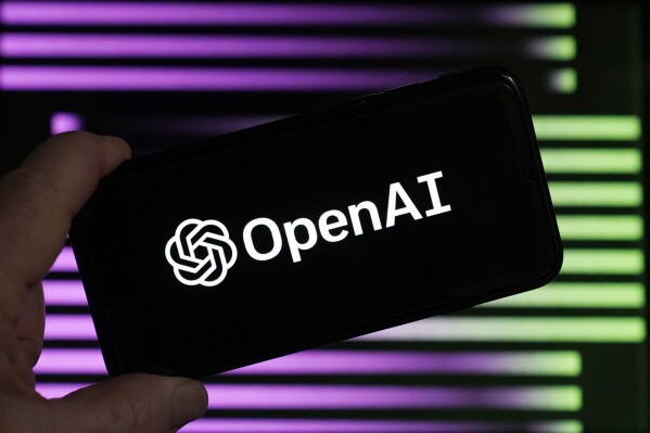 FILE - The logo for OpenAI, the maker of ChatGPT, appears on a mobile phone, in New York, Tuesday, Jan. 31, 2023. ChatGPT-maker OpenAI and The Associated Press said Thursday that they've made a deal for the artificial intelligence company to license AP's archive of news stories. (AP Photo/Richard Drew, File)