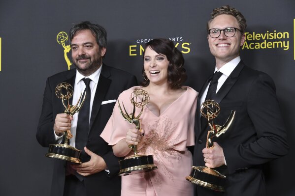 FILE - This Sept. 14, 2019 file photo shows Adam Schlesinger, from left, Rachel Bloom and Jack Dolgen in the press room with the awards for outstanding original music and lyrics for "Crazy Ex Girlfriend" at the Creative Arts Emmy Awards in Los Angeles. Schlesinger, an Emmy and Grammy winning musician and songwriter known for his band Fountains of Wayne and his songwriting on the TV show “Crazy Ex-Girlfriend,” has died from coronavirus at age 51. (Photo by Richard Shotwell/Invision/AP, File)