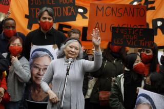FILE - In this Jan.30, 2021 file photo, Tran To Nga waves as she delivers a speech during a gathering in support of people exposed to Agent Orange during the Vietnam War, in Paris. A French court dismissed on Monday the case of a French-Vietnamese woman who sued 14 companies that produced and sold the powerful defoliant dioxin Agent Orange used by U.S. troops during the Vietnam War, her lawyers said. Tran To Nga, a 79-year-old former journalist, will appeal the decision, according to her legal team.(AP Photo/Thibault Camus, File)