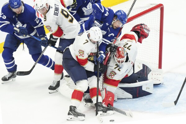 Florida Panthers defenceman Dmitry Kulikov (7) holds back Toronto Maple Leafs centre Auston Matthews (34) as teammate Sergei Bobrovsky (72) makes a save during the third period of an NHL Stanley Cup playoff hockey game in Toronto, Sunday, May 18, 2025. (Chris Young/The Canadian Press via AP)