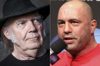 This combination photo shows Neil Young in Calabasas, Calif., on May 18, 2016, left, and UFC announcer and podcaster Joe Rogan before a UFC on FOX 5 event in Seattle, Dec. 7, 2012. Spotify said Sunday, Jan. 30, 2022, that it will add content advisories before podcasts discussing the coronavirus. The move follows protests of the music streaming service that were kicked off by Young over the spread of COVID-19 vaccine misinformation. On Wednesday, Young had his music removed from Spotify after the tech giant declined to remove episodes of “The Joe Rogan Experience,” which has been criticized for spreading virus misinformation. (AP Photo)