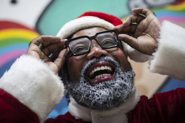 Rodrigo Franca prepares for his role as "Papai Negro" or Black Santa, for a Christmas event at a school in the City of God favela in Rio de Janeiro, Brazil, Monday, Dec. 11, 2023. (AP Photo/Bruna Prado)