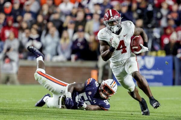 FILE - Alabama running back Brian Robinson Jr. (4) carries the ball against Auburn during the second half of an NCAA college football game Nov. 27, 2021, in Auburn, Ala. Robinson's tough yet shifty running style has netted 1,071 yards and an SEC-best 14 touchdowns despite his missing one game and part of another because of injuries. (AP Photo/Butch Dill, File)