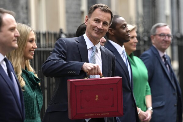 Britain's Chancellor of the Exchequer Jeremy Hunt holds his traditional red ministerial box as he leaves 11 Downing Street for the House of Commons to deliver the Budget in London, Wednesday, March 6, 2024. (AP Photo/Frank Augstein)