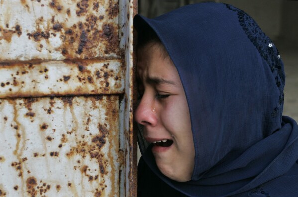 FILE - A Palestinian woman, who had ten relatives killed near a United Nations school, weeps during their funeral in the Jebaliya refugee camp, in the northern Gaza Strip, Jan. 7, 2009, while Israeli forces paused their assault on Hamas. (AP Photo/Hatem Moussa, File)