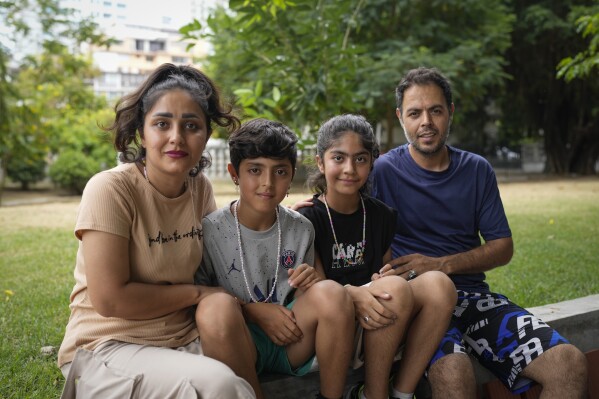 Ebrahim Ghezelgechi, right, a migrant from Iran, poses for a portrait with his wife Sahar Bideman and their children Sam and Aylin in Panama City, Monday, March 10, 2025, after they were deported from the U.S., detained for weeks in a Panamanian immigration camp, and released on a temporary humanitarian visa allowing a 30‑day stay. (AP Photo/Matias Delacroix)