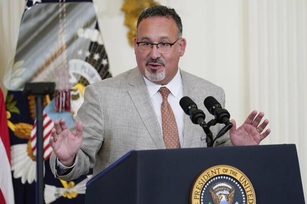 FILE - Education Secretary Miguel Cardona speaks in the East Room of the White House in Washington, April 27, 2022. The Biden administration proposed a dramatic rewrite of campus sexual assault rules on Thursday, June 23, moving to expand protections for LGBTQ students, bolster the rights of victims and widen colleges' responsibilities in addressing sexual misconduct. The proposal was announced on the 50th anniversary of the Title IX women’s rights law. Cardona said Title IX has been “instrumental” in fighting sexual assault and violence in education. (AP Photo/Susan Walsh, File)