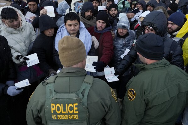 FILE - Border Patrol agents ask asylum-seeking migrants to line up in a makeshift, mountainous campsite after the group crossed the border with Mexico,Feb. 2, 2024, near Jacumba Hot Springs, Calif. The number of arrests for illegally crossing the U.S. southern border with Mexico nudged upward February over the previous month. But at a time when immigration is increasingly a concern for voters, the numbers were still among the lowest of Joe Biden's presidency. (AP Photo/Gregory Bull, File)