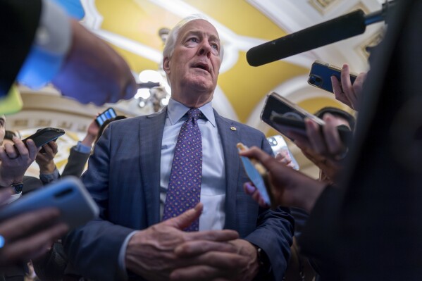 FILE - Sen. John Cornyn, R-Texas, is surrounded by reporters as he heads to the chamber at the Capitol in Washington, Feb. 7, 2024. Cornyn has informed his colleagues that he intends to run for Senate Republican leader. He's the first senator to announce a campaign after Sen. Mitch McConnell said on Wednesday that he'll step down from the post in November. (AP Photo/J. Scott Applewhite, File)
