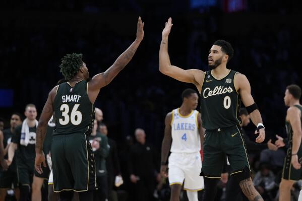 Boston Celtics' Jayson Tatum (0) and Marcus Smart (36) high-five during first half of an NBA basketball game against the Los Angeles Lakers Tuesday, Dec. 13, 2022, in Los Angeles. (AP Photo/Jae C. Hong)