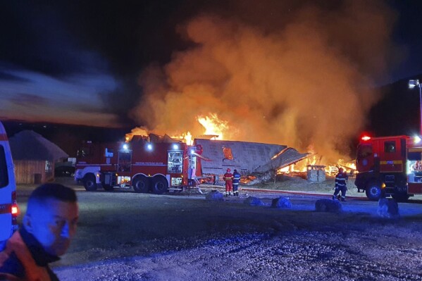 In this photo released by the Romanian Emergency Services Prahova (ISU Prahova), a guesthouse is burning in Tohani, Romania, Tuesday, Dec. 26, 2023. A huge fire at a guesthouse in Romania on Tuesday morning has left several people dead, including a child, and some people are missing, authorities said. (Romanian Emergency Services - ISU Prahova via AP)