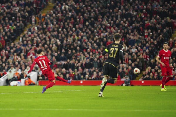 Liverpool's Mohamed Salah, left, scores his side's third goall during the Europa League round of 16, second leg, soccer match between Liverpool and Sparta Praha at Anfield Stadium, Liverpool, England, Thursday March 14, 2024. (AP Photo/Jon Super)