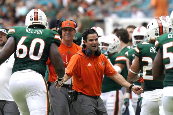 Miami head coach Manny Diaz, center, greets Miami offensive lineman Zion Nelson (60) and running back Cody Brown after Brown scored a touchdown during the first half of an NCAA college football game against Central Connecticut State, Saturday, Sept. 25, 2021, in Miami Gardens, Fla. (AP Photo/Lynne Sladky)