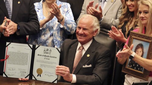 South Carolina Gov. Henry McMaster holds up an ignition interlock bill at a signing ceremony in Columbia, S.C., Wednesday, July 12, 2023. The state is expanding the number of drunk driving offenders who must install temporary breathalyzers before taking the wheel. (AP Photo/James Pollard)