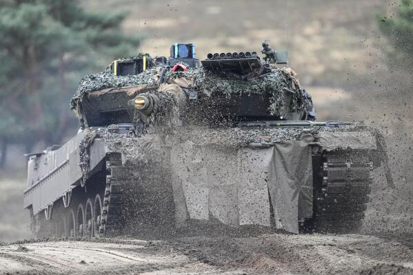 FILE -- A Leopard 2 tank is seen in action during a visit of German Defense Minister Boris Pistorius at the Bundeswehr tank battalion 203 at the Field Marshal Rommel Barracks in Augustdorf, Germany, Wednesday, Feb. 1, 2023. Nearly a year after Chancellor Olaf Scholz declared Russia’s invasion of Ukraine a 'turning point' that would trigger German weapons supplies to a country at war and a massive increase in spending on the German armed forces, his country’s military turnaround still has a long way to go. (AP Photo/Martin Meissner, file)