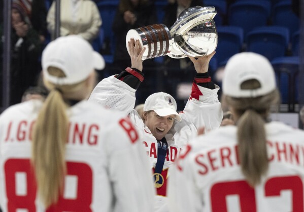 Canada goaltender Ann-Renee Desbiens (35) hoists the trophy following their gold medal win over United States at the women's world hockey championships in Utica, N.Y., Sunday, April 14, 2024. (Christinne Muschi/The Canadian Press via AP)