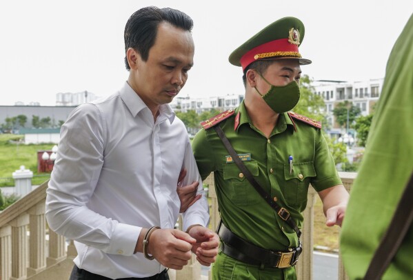 Trinh Van Quyet, a prominent Vietnamese business tycoon, is escorted to a court for his trial of defrauding stockholders, in Hanoi, Vietnam, July 22, 2024. (AP Photo/Anh Tuc)