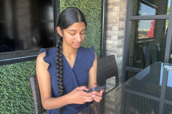 Shreya Nallamothu looks at her phone in Bloomington, Ill., on Tuesday, May 9, 2023. Illinois lawmakers aim to make their state what they say will be the first in the country to create protections for child social media influencers. Nallamothu, 15, raised her concerns to Illinois state Sen. David Koehler of Peoria, who then set the legislation in motion. (AP Photo/Claire Savage)