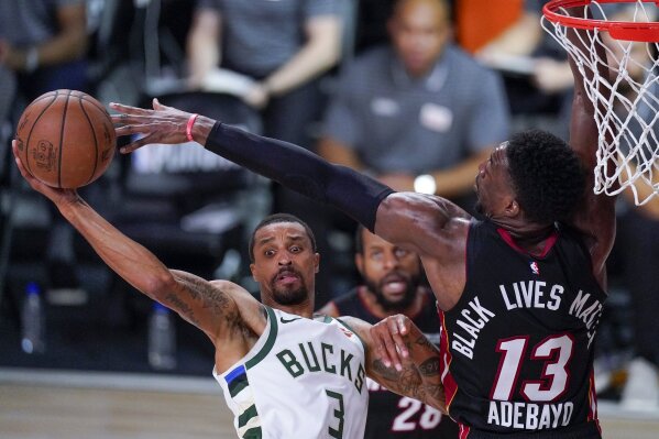 Milwaukee Bucks' George Hill tries to pass around Miami Heat's Bam Adebayo (13) during the second half of an NBA conference semifinal playoff basketball game Sunday, Sept. 6, 2020, in Lake Buena Vista, Fla. (AP Photo/Mark J. Terrill)