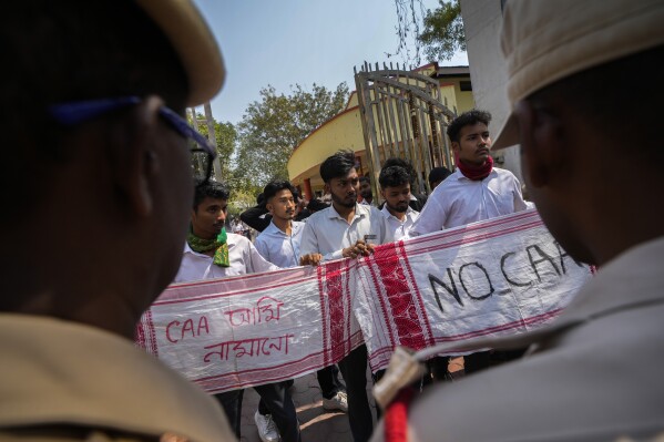 Students protest against the Citizenship Amendment Act (CAA) in Guwahati, India, Tuesday, March 12, 2024. India has implemented a controversial citizenship law that has been widely criticized for excluding Muslims, a minority community whose concerns have heightened under Prime Minister Narendra Modi’s Hindu nationalist government. The Citizenship Amendment Act provides a fast track to naturalization for Hindus, Parsis, Sikhs, Buddhists, Jains and Christians who fled to Hindu-majority India from Afghanistan, Bangladesh and Pakistan before Dec. 31, 2014. Banner in Assamese reads, "we will not accept CAA " (AP Photo/Anupam Nath)