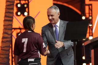 MLB Commissioner Rob Manfred, right, shakes hands with Willa suarez, of Uvalde, Tex., during the 2022 MLB baseball draft, Sunday, July 17, 2022, in Los Angeles. (AP Photo/Abbie Parr)