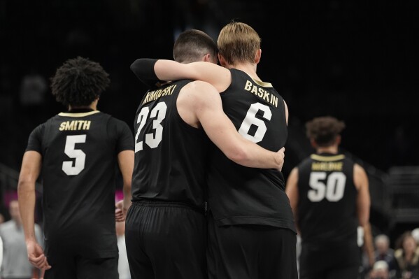 Colorado's Trevor Baskin (6) hugs teammate Andrej Jakimovski (23) after defeating West Virginia during an NCAA college basketball game in the second round of the Big 12 Conference tournament, Wednesday, March 12, 2025, in Kansas City, Mo. (AP Photo/Charlie Riedel)