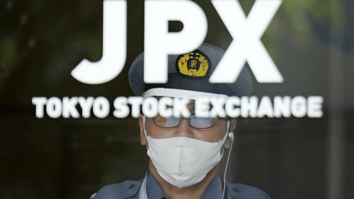 A security guard stands guard at an entrance of Tokyo Sock Exchange building Tuesday, July 18, 2023, in Tokyo. (AP Photo/Eugene Hoshiko)
