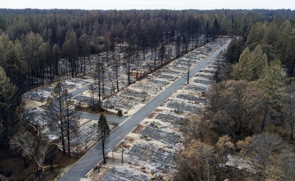 FILE - This Dec. 3, 2018, file photo, shows homes leveled by the Camp Fire line at the Ridgewood Mobile Home Park retirement community in Paradise, Calif. Pacific Gas & Electric officials are to be expected to appear in court Tuesday, June 16, 2020, to plead guilty for the deadly wildfire that nearly wiped out the Northern California town of Paradise in 2018. (AP Photo/Noah Berger, File)