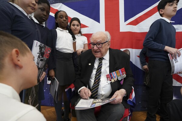 D-Day veteran and Ambassador for the British Normandy Memorial, Ken Hay, 98, who served with the 4th Dorset Regiment, speaks to children during a visit to Rush Green Primary School in Dagenham, England, Monday May 20, 2024, ahead of the 80th anniversary of the D-Day landings. (Gareth Fuller/PA via AP)