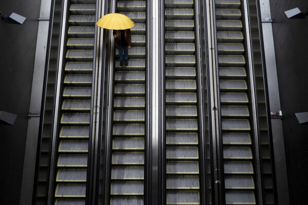 A person with an umbrella goes down an escalator at a subway station during heavy rain in Santiago, Chile, Thursday, June 13, 2024. (AP Photo/Matias Basualdo)