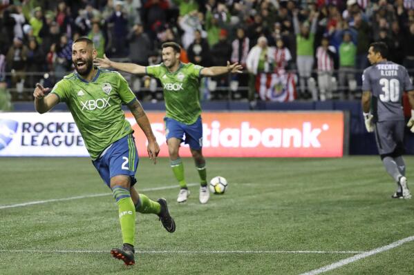FILE - Seattle Sounders forward Clint Dempsey, left, celebrates after he scored a goal on Guadalajara goalkeeper Rodolfo Cota, right, during the second half of a CONCACAF Champions League soccer match Wednesday, March 7, 2018, in Seattle. Four years removed from playing, Dempsey is set to be inducted into the U.S. National Soccer Hall of Fame on Saturday, May 21, 2022. (AP Photo/Ted S. Warren, File)