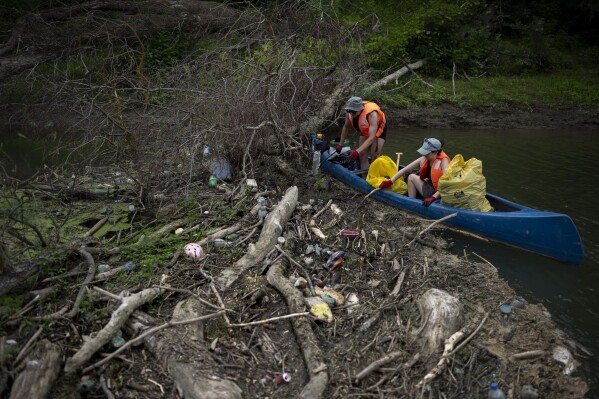Volunteers collect rubbish from the banks of Tisza river near Tiszaroff, Hungary, Tuesday, Aug. 1, 2023. (AP Photo/Denes Erdos)