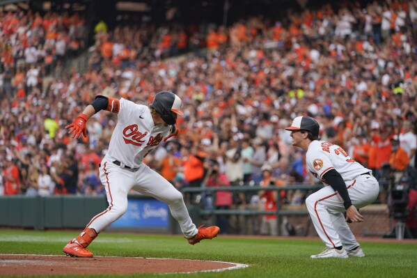 Baltimore Orioles' Gunnar Henderson, left, celebrates with Adley Rutschman after Henderson scored both of them on a two-run home run off New York Mets starting pitcher Tylor Megill in the first inning of a baseball game, Saturday, Aug. 5, 2023, in Baltimore. (AP Photo/Julio Cortez)