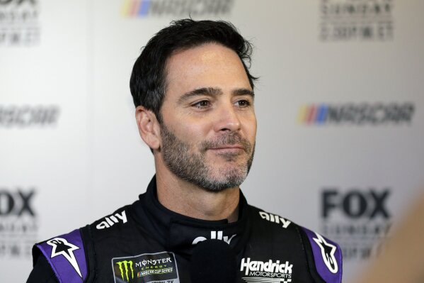 FILE - In this Feb. 13, 2019, file photo, driver Jimmie Johnson smiles during media day for the NASCAR Daytona 500 auto race at Daytona International Speedway in Daytona Beach, Fla.  As he prepares for his final season of full-time racing, the most accomplished driver of his generation has changed his mindset. “I’m not chasing anything,” said Johnson, who is determined to enjoy his 19th and final Cup season. (AP Photo/Terry Renna, File)