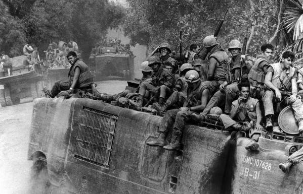 FILE- An amphibious tracked vehicle with a load of fully-armed Marines approaches a river southwest of Danang, South Vietnam, Aug. 22, 1969. (AP Photo/Horst Faas, File)
