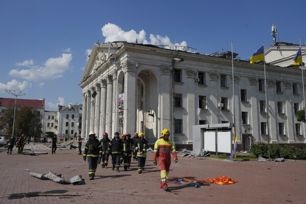 Firefighters walk next to the Taras Shevchenko Chernihiv Regional Academic Music and Drama Theatre damaged by a Russian attack in Chernihiv, Ukraine, Saturday, Aug. 19, 2023. (AP Photo/Efrem Lukatsky)
