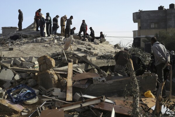 Palestinos observam a destruição após um ataque israelense a um prédio residencial em Rafah, Faixa de Gaza, domingo, 3 de março de 2024. (AP Photo/Hatem Ali)