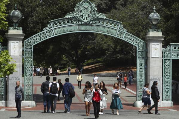 FILE - Students walk past Sather Gate on the University of California at Berkeley campus in Berkeley, Calif., May 10, 2018. California lawmakers are fast-tracking a proposal that could allow the University of California, Berkeley, to admit as many students as it planned for the fall semester despite a judicial freeze on enrollment. Both the Senate and Assembly are scheduled to vote on the idea on Monday, March 14, 2022. (AP Photo/Ben Margot, File)
