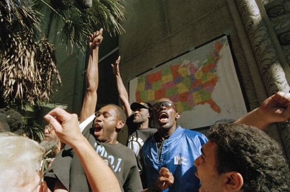 FILE - Supporters of O.J. Simpson react outside the Criminal Courts Building to the verdict of not guilty in Simpson's double-murder trial in Los Angeles, Oct. 3, 1995. For many people old enough to remember O.J. Simpson's murder trial, his 1994 exoneration was a defining moment in their understanding of race, policing and justice. Nearly three decades later, it still reflects the different realities of white and Black Americans. (AP Photo/Elise Amendola, File)