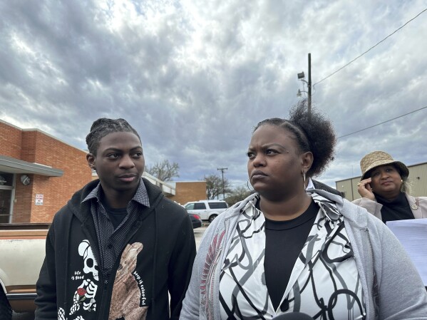 Daryl George, an 18-year-old high school student, and his mother Daresha George stand in court in Anawaque, Texas, Wednesday, Jan. 24, 2024. A judge on Wednesday ordered a trial next month to determine whether George can continue to be punished by his district for refusing to change his hairstyle, which he and his family say is protected by a new state law.  (AP Photo/Juan A. Lozano)