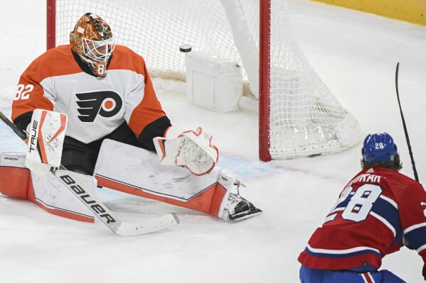 Montreal Canadiens' Christian Dvorak (28) scores against Philadelphia Flyers Ivan Fedotov goaltender during the second period of an NHL hockey game in Montreal, Tuesday, April 9, 2024. (Graham Hughes/The Canadian Press via AP)