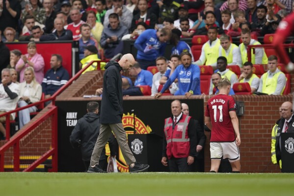 Manchester United's Rasmus Hojlund, right, leaves the pitch after being replaced as his coach Erik ten Hag walks on the sideline during the English Premier League soccer match between Manchester United and Brighton and Hove Albion at Old Trafford stadium in Manchester, England, Saturday, Sept. 16, 2023. (AP Photo/Dave Thompson)