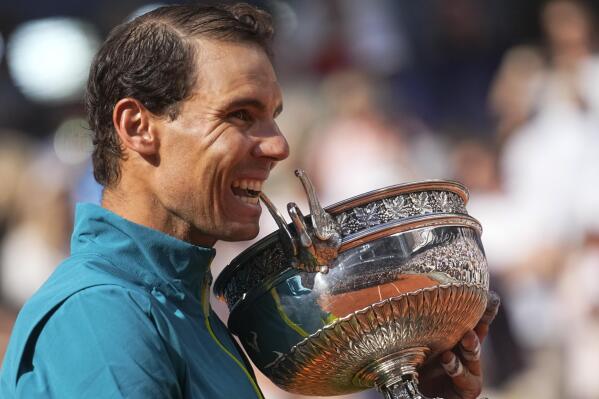 Spain's Rafael Nadal bites the trophy after winning the final match against Norway's Casper Ruud in three sets, 6-3, 6-3, 6-0, at the French Open tennis tournament in Roland Garros stadium in Paris, France, Sunday, June 5, 2022. (AP Photo/Michel Euler)