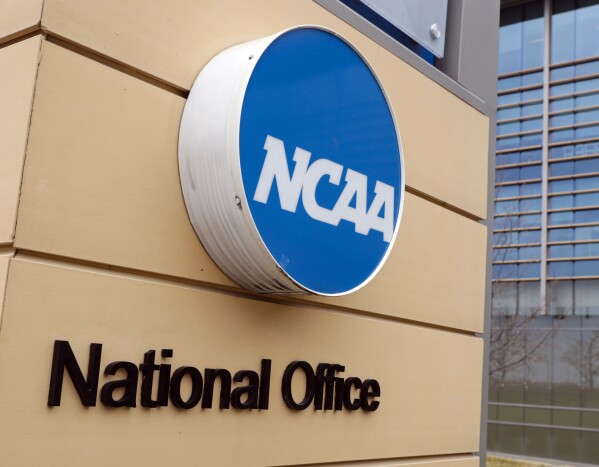 FILE - Signage is on the headquarters of the NCAA in Indianapolis, March 12, 2020. The NCAA and the nation's five biggest conferences have agreed to pay nearly $2.8 billion to settle a host of antitrust claims,a monumental decision that sets the stage for a groundbreaking revenue-sharing model that could start directing millions of dollars directly to athletes as soon as the 2025 fall semester. (AP Photo/Michael Conroy, File)