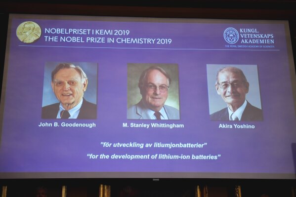 A screen displays the laureates of the 2019 Nobel Prize in Chemistry, from left, John B. Goodenough, M. Stanley Whittingham, and Akira Yoshino "for the development of lithium-ion batteries", during a news conference at the Royal Swedish Academy of Sciences in Stockholm, Sweden, Wednesday Oct. 9, 2019. (Naina Helen Jama/TT via AP)