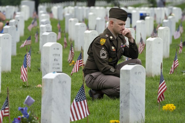 A member of the Army visits Section 60 of Arlington National Cemetery, in Arlington, Va., Monday, May 27, 2024, on Memorial Day. (AP Photo/Jacquelyn Martin, File)