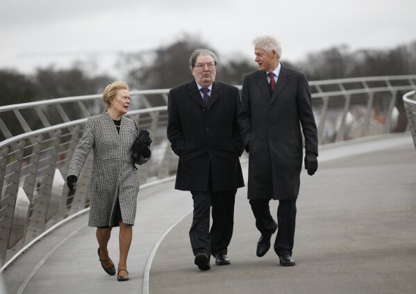 FILE - In this March 5, 2014 file photo former US President Bill Clinton, right, with former Social Democratic Labour Party leader John Hume and Hume's wife Pat walk across the Peace Bridge, in Londonderry Northern Ireland. The family of politician John Hume, who won Nobel Peace Prize for work to end violence in Northern Ireland, says he has died. He was 83. The Catholic leader of the moderate Social Democratic and Labour Party , Hume was regarded by many as the principal architect behind the peace agreement. (AP Photo/Peter Morrison)