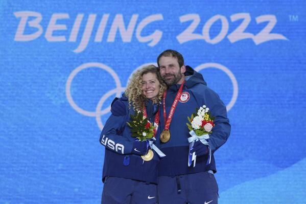 Gold medalists United States' Lindsey Jacobellis and Nick Baumgartner celebrates during a medal ceremony for the mixed team snowboard cross at the 2022 Winter Olympics, Saturday, Feb. 12, 2022, in Zhangjiakou, China. (AP Photo/Gregory Bull)